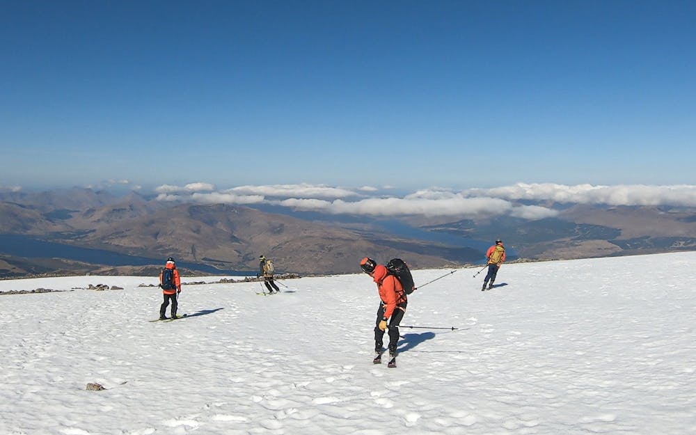 The team descending open summit slopes from Ben Nevis before dropping into the steeps to the right