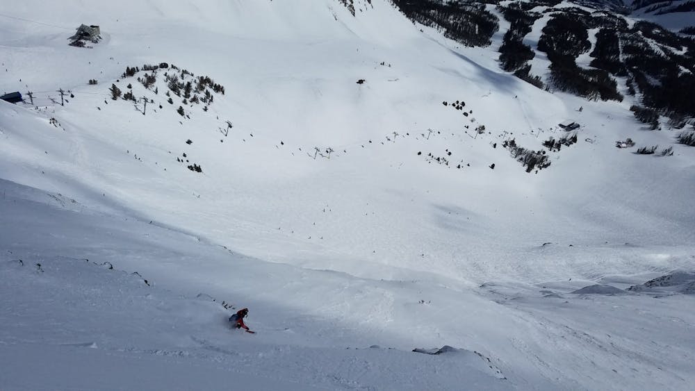 Skier carves a turn on upper 5th Gully