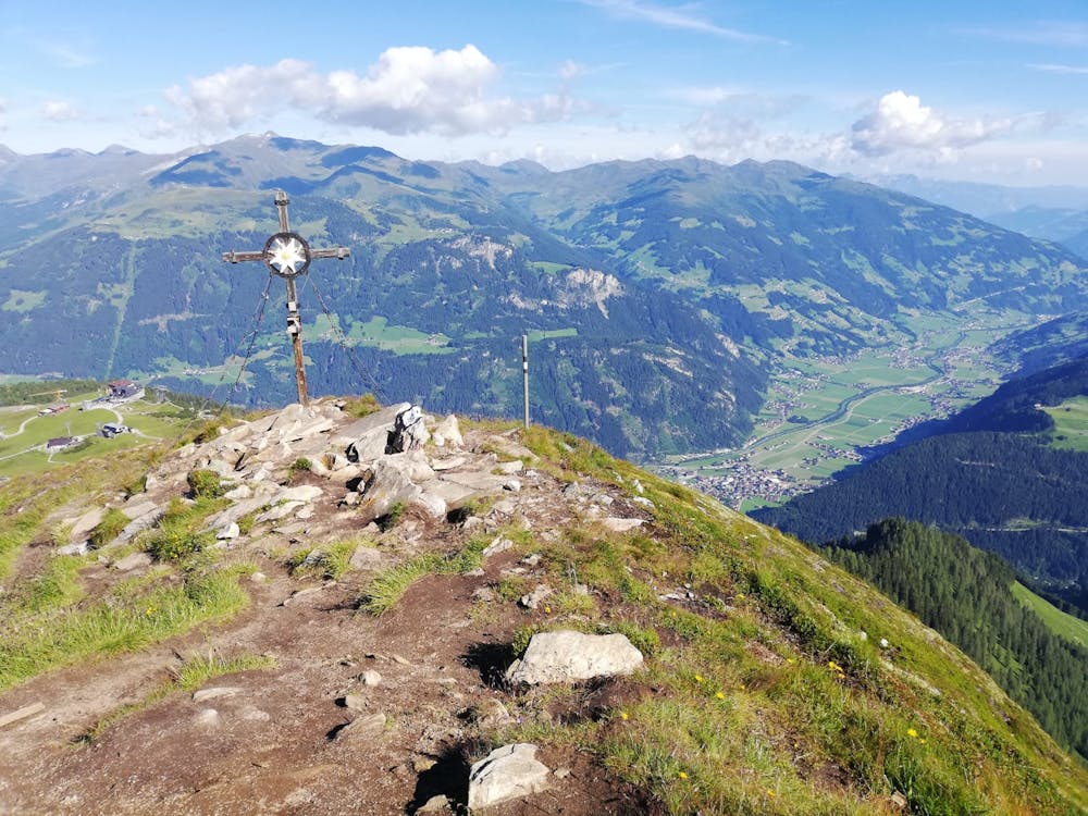 The summit cross with the Zillertal valley behind.