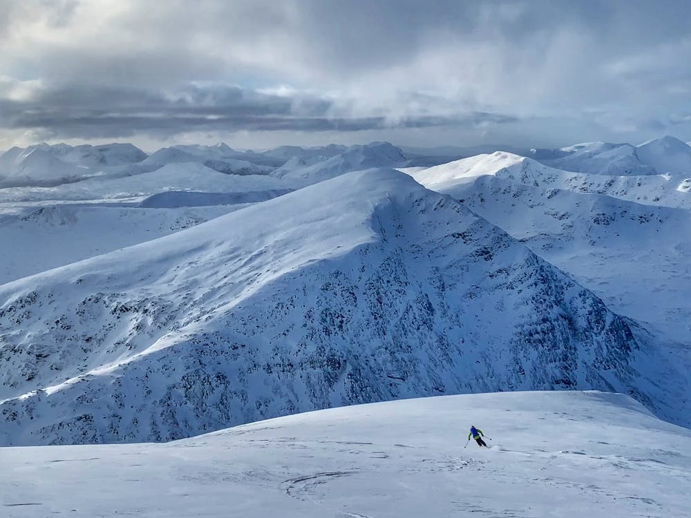 Skiing off the summit with Sgurr Breac in the background