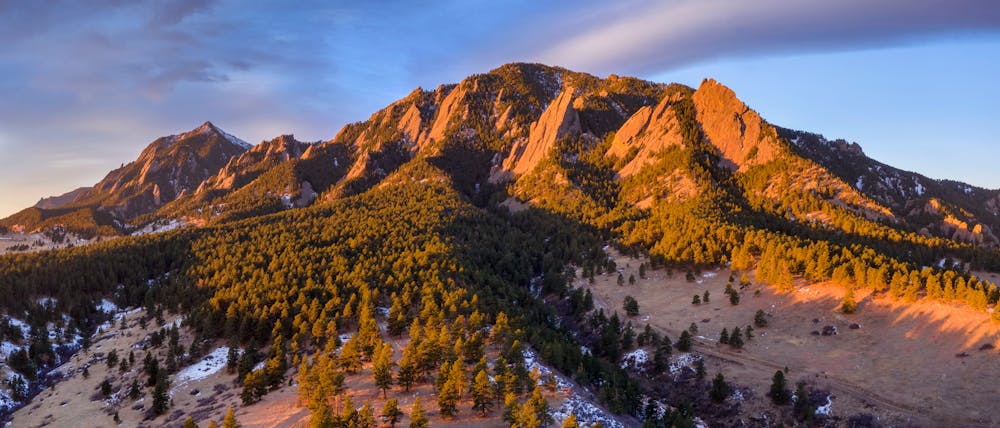 Panoramic aerial of Green Mountain with Bear Peak in the distance just after sunrise in Boulder, Colorado in winter.