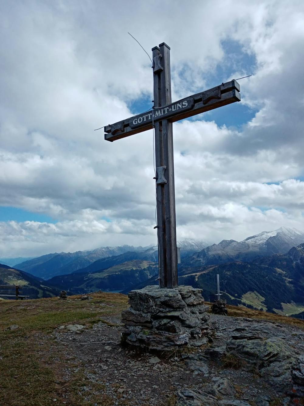 The summit cross with the Hohe Tauern range visible behind. 