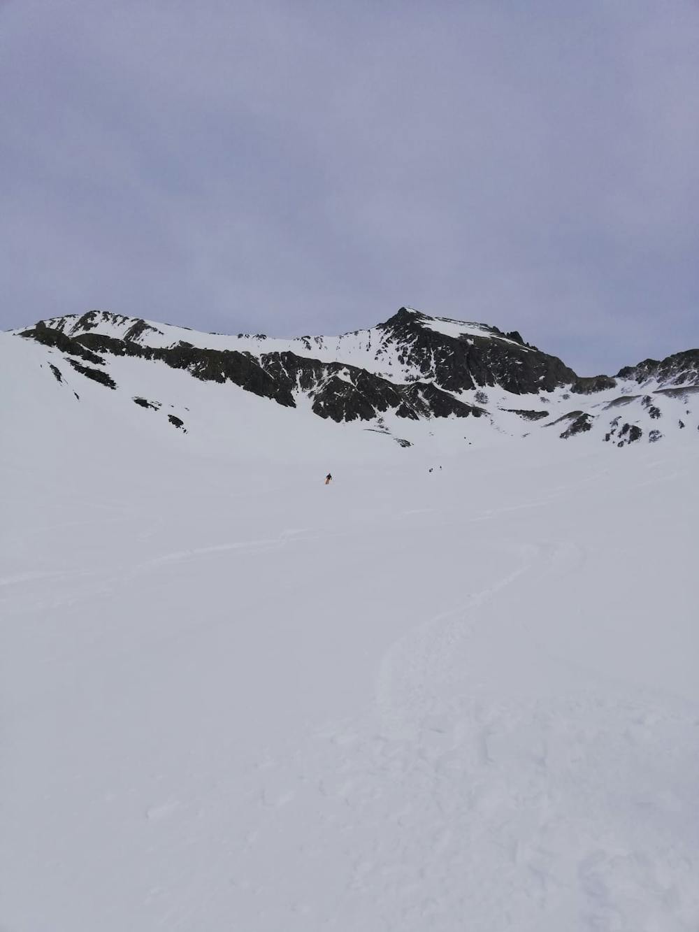 Looking back up at the upper section of the route, with a skier coming down.